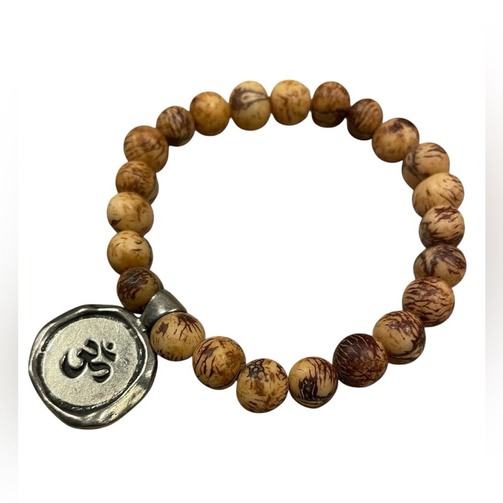 Natural açai seeds or picture jasper beads and a metal charm with the Om symbol.
